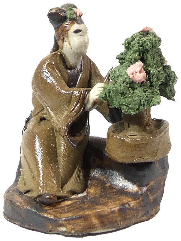 Handbemalte Miniatur eines Bonsai-Meisters bei der Gestaltung.